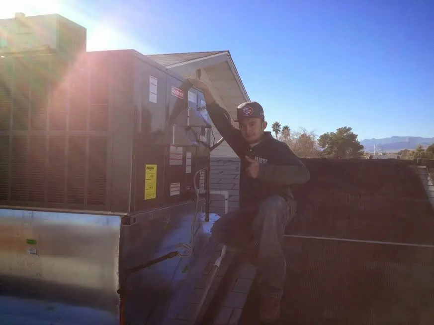 HVAC technician performing Boiler Repair on a rooftop unit in Georges